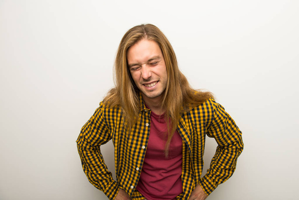Szőke férfi hosszú haja és kockás inget, boldog és mosolyog - Fotó, kép
