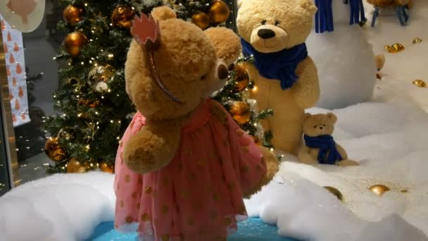Princess toy brown teddy bear in a dress and crown spinning around in a Christmas-decorated shopping center - Footage, Video