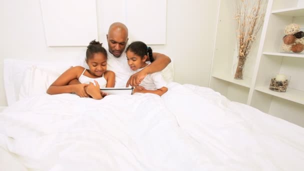 Afrikanische amerikanische Töchter Eltern spielen Bett drahtlose Technologie - Filmmaterial, Video