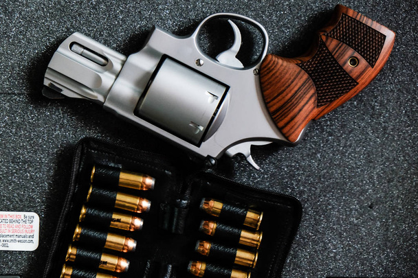 revólver de metal .44 pistola magnum com jaqueta ponto macio (JSP) bala no fundo escuro
 - Foto, Imagem