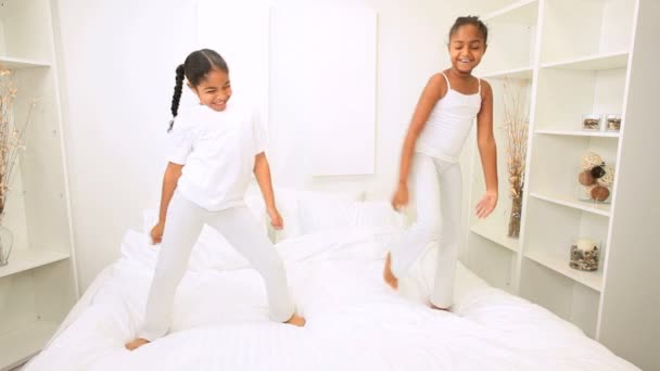 junge ethnische Schwestern tanzen Bett - Filmmaterial, Video