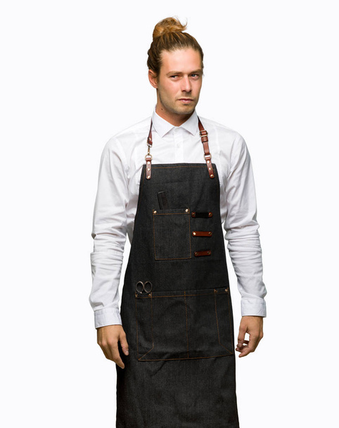 Barber man in an apron feeling upset on isolated background - Photo, Image