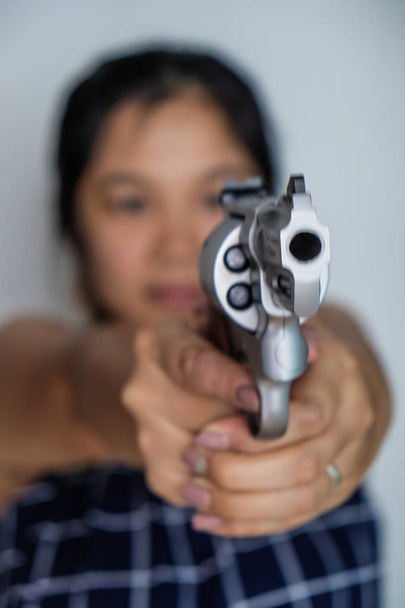 Жінки стріляють з револьвера .357 .44 magnum на білому тлі
 - Фото, зображення
