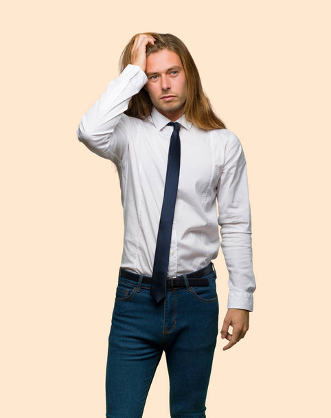 Empresário loiro com cabelos longos com uma expressão de frustração e não compreensão em fundo isolado
 - Foto, Imagem