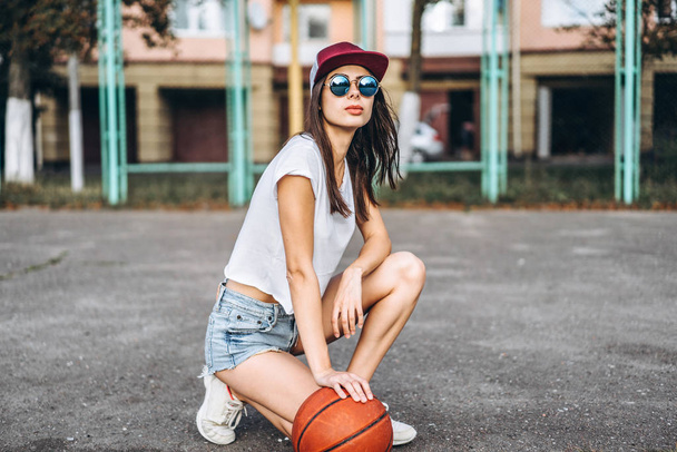 Pretty young sporty girl with basketball ball outdoor - Φωτογραφία, εικόνα