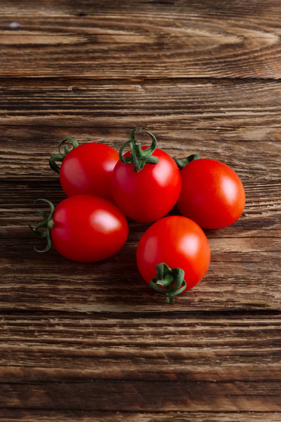 Five fresh cherry tomatoes on wooden table - Fotografie, Obrázek
