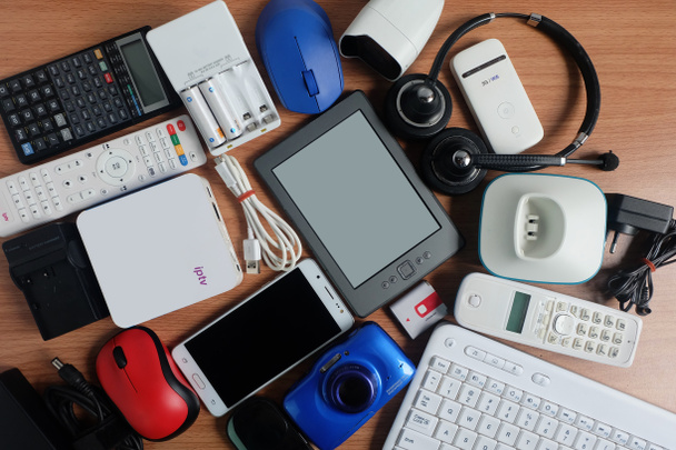 gadgets eletrônicos modernos usados para uso diário no piso de madeira, conceito de reutilização e reciclagem, vista superior
 - Foto, Imagem