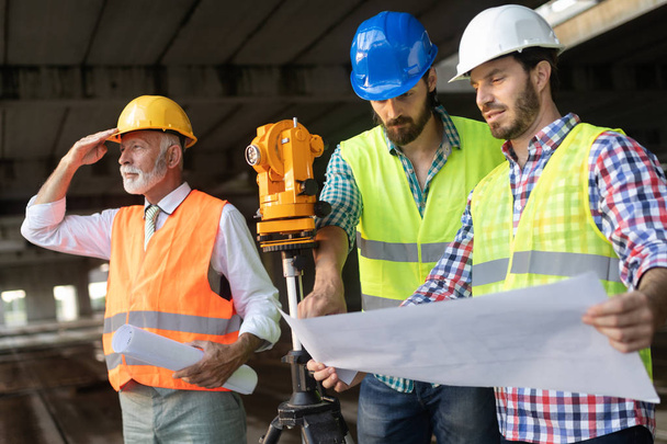Engineer, contractor, architect, investor teamwork. Group of construction people talking and planning work, holding blueprint - Foto, Imagen