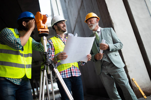 Engineer, contractor, architect, investor teamwork. Group of construction people talking and planning work, holding blueprint - Foto, Imagen