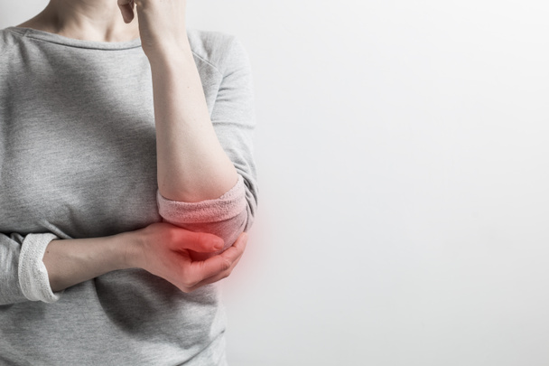 Pain in the elbow. A woman holds on to a sore elbow. - Photo, Image