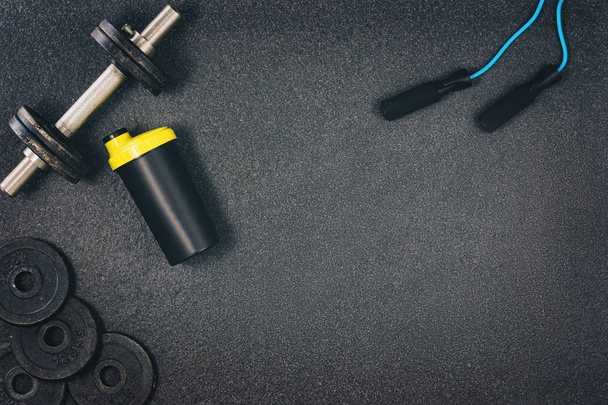 Fitness or bodybuilding background. Dumbbells on gym floor, top view - Foto, Bild