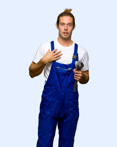 Workman surprised and shocked while looking right on isolated background - Foto, imagen