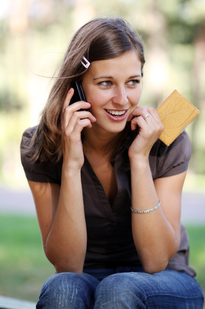 Onnellinen nuori nainen soittaa puhelimitse
 - Valokuva, kuva