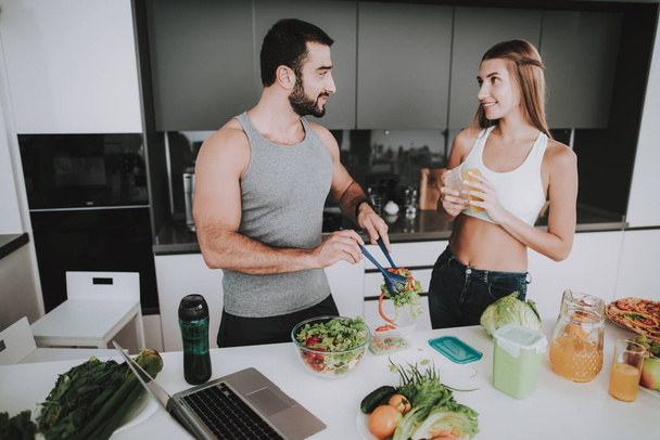 A Couple Is Preparing A Salad For A Breakfast. Cooking Together.. Healthy Lifestyle. Young And Handsome. Sport Body. House Interior. Dish Chopping. Morning Fresh Nutrition Concept. - Фото, изображение