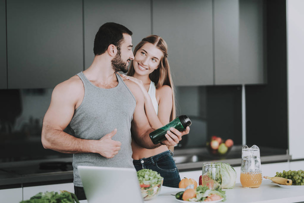 Sporty Couple On Kitchen. Vegetables Cocktail. Healthy Lifestyle Concept. Cooking Together. Sporty Athletic Family. Young And Beautiful. Fresh Nutrition. Holiday Leisure. Thumbs Up. - Фото, зображення