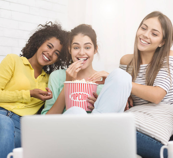 Девушки смотрят комедию и едят попкорн дома
 - Фото, изображение