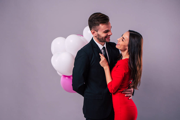 Happy couple posing on grey background - Foto, imagen
