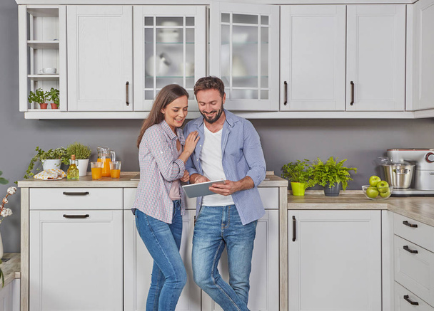 Jeune couple dans la cuisine avec tablette numérique
 - Photo, image