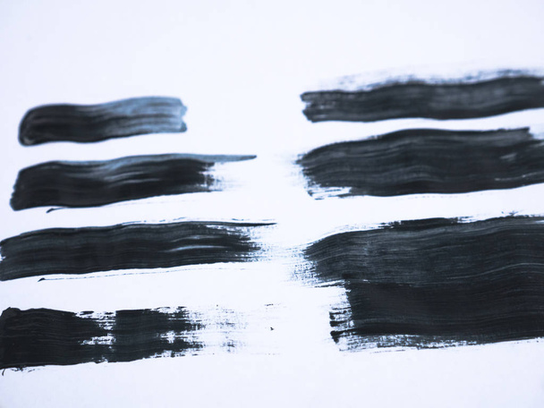 Black acrylic paint stroke isolated on white background, abstract art concept - Фото, изображение