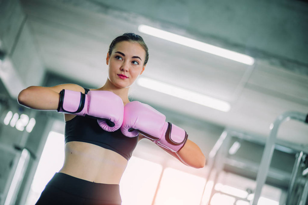 Fit beautiful woman boxer hitting a huge punching bag exercise class in a gym. Boxer woman making direct hit dynamic movement. Healthy, sports, lifestyle, Fitness, workout concept. With copy space. - Foto, Imagem