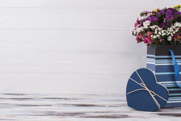 Πολύχρωμα λουλούδια σε μπλε τσάντα και ελεύθερο χώρο για το κείμενο. - Φωτογραφία, εικόνα
