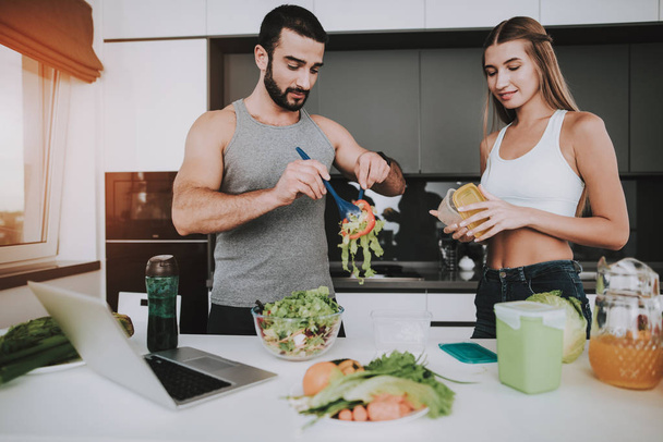 A Couple Is Preparing A Salad For A Breakfast. Cooking Together.. Healthy Lifestyle. Young And Handsome. Sport Body. House Interior. Dish Chopping. Morning Fresh Nutrition Concept. - Фото, зображення