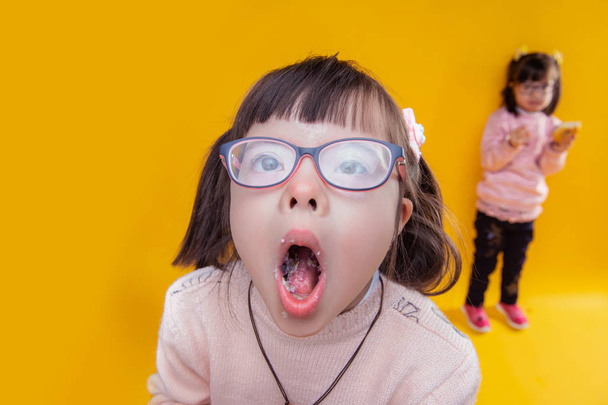 Dark-haired girl with down syndrome opening her mouth - Photo, Image