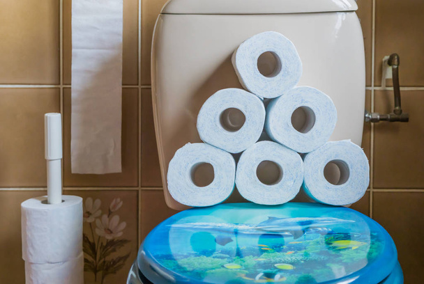 halom halmozott WC-papír a vízszekrény ülés, belső fürdőszoba, egészségügyi háttér - Fotó, kép