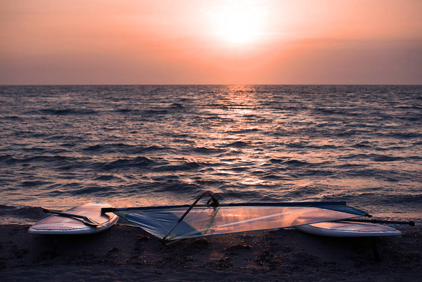 Sup-Bretter liegen im Sonnenuntergang auf Sand - Foto, Bild