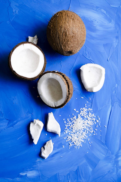 coconut slices and milk on blue background - Фото, изображение