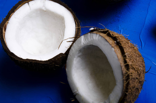 coconut slices and milk on blue background - Foto, afbeelding