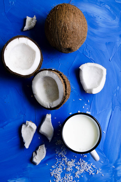 coconut slices and milk on blue background - Foto, imagen