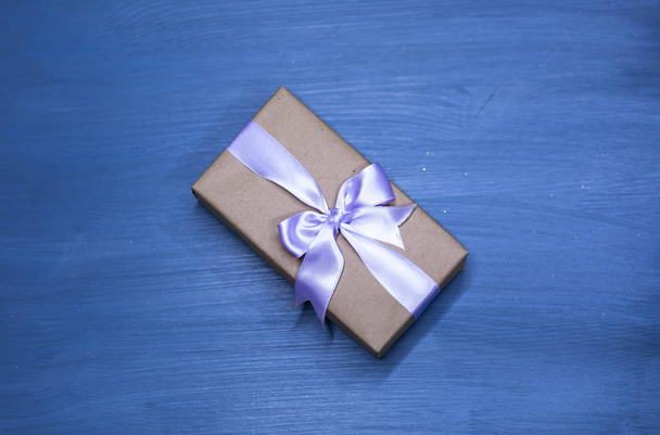 Flat lay of romantic gift wrapped and decorated with bow on blue background - Foto, Bild