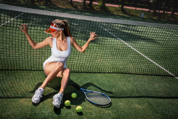 Chica atractiva en uniforme en la cancha de tenis
 - Foto, imagen