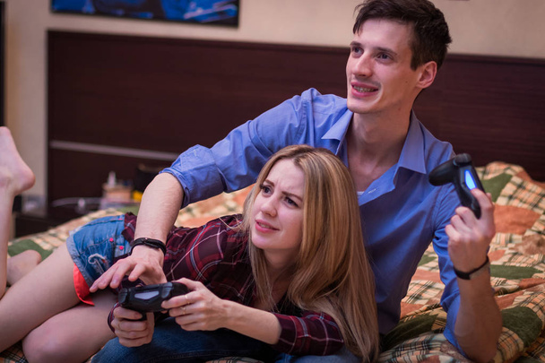 Un gars avec une fille, jouant émotionnellement à des jeux informatiques
. - Photo, image