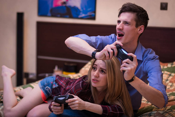 Un tipo con una chica, jugando emocionalmente juegos de ordenador
. - Foto, Imagen