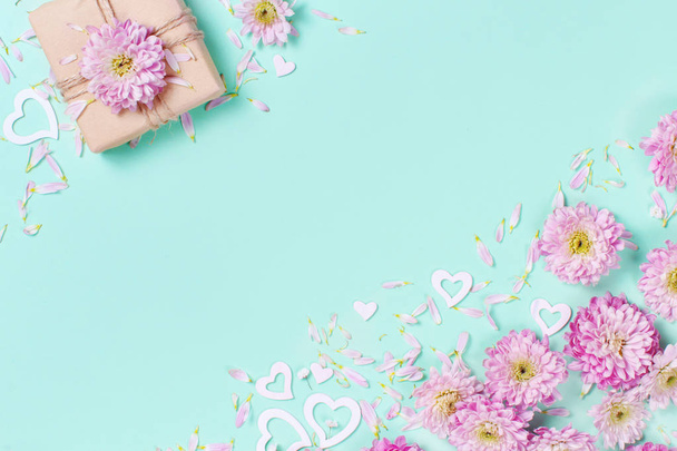 Spring composition with flowers, petals, hearts and gift box on a pastel  background - Photo, Image