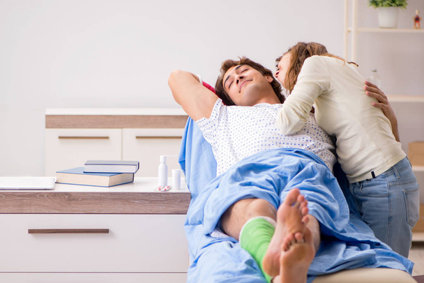 Liebevolle Ehefrau kümmert sich im Krankenhaus um verletzten Ehemann  - Foto, Bild