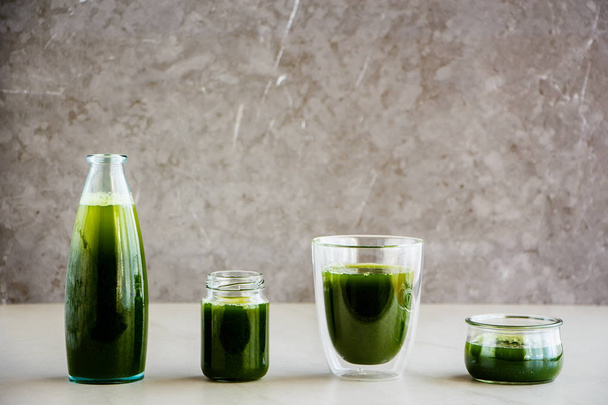 Утром зеленый детокс смузи или сок в стаканах, серый фон, пространство для копирования. Здоровый веган, вегетарианский завтрак, сезонная детоксикация, щелочная диета, концепция потери веса - Образ
  - Фото, изображение