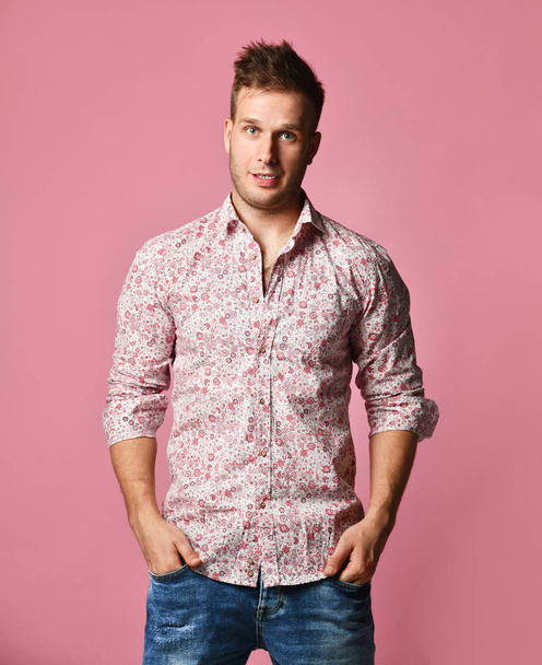 Young successful happy smiling business man in shirt and blue jeans standing posing on pink background - Fotoğraf, Görsel