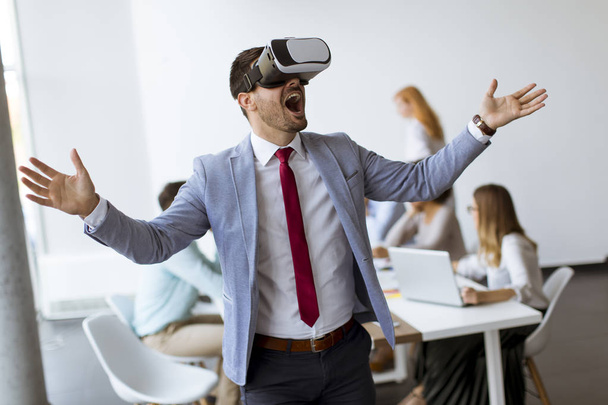 Businessman making team training exercise during team building seminar using VR glasses in office - Photo, Image