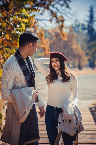 Youthful couple is spending the day outdoors in the park, talking and enjoying the sunny day - Foto, Imagen