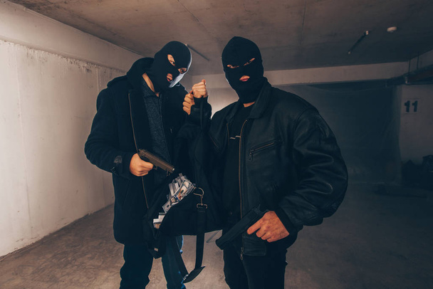 Assaulters fegyvereket és a lopott pénzt egy sötét szobában állandó - Fotó, kép
