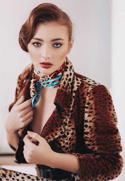 Beautiful young woman posing in leopard coat - Фото, зображення