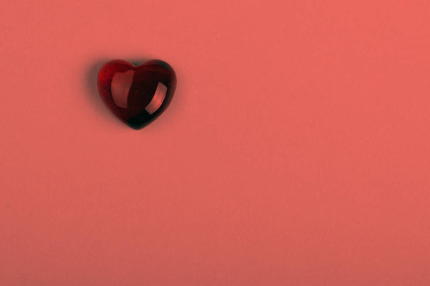 Червоне скляне серце як символ дня Святого Валентина на фоні кольору живого коралу
 - Фото, зображення