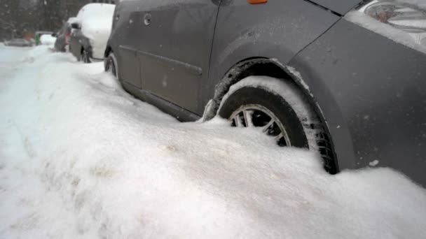 Close up van de wielen van de auto vast te zitten in de sneeuw drift. - Video