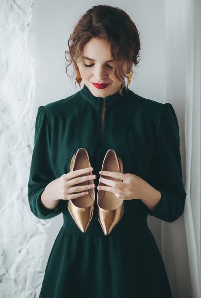 Όμορφη νεαρή γυναίκα που ποζάρει στο πράσινο φόρεμα και παπούτσια - Φωτογραφία, εικόνα