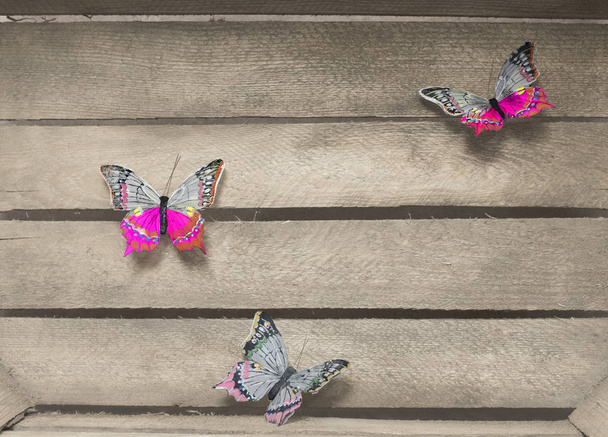 Papillons décoratifs de différentes couleurs sur un fond en bois
 - Photo, image
