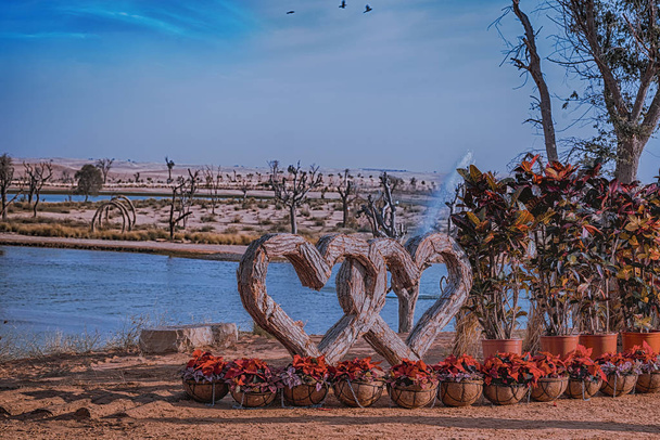 Cuore di legno impigliato al Dubai Love Lake con fontana e acqua intorno. Love Lake Dubai è la nuova destinazione turistica di Dubai
. - Foto, immagini