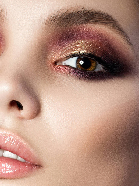 Beauty portrait of young woman with modern smokey eyes. Perfect skin and fashion makeup. Sensuality, trendy luxurious makeup and cosmetology concept. Studio shot. - Φωτογραφία, εικόνα